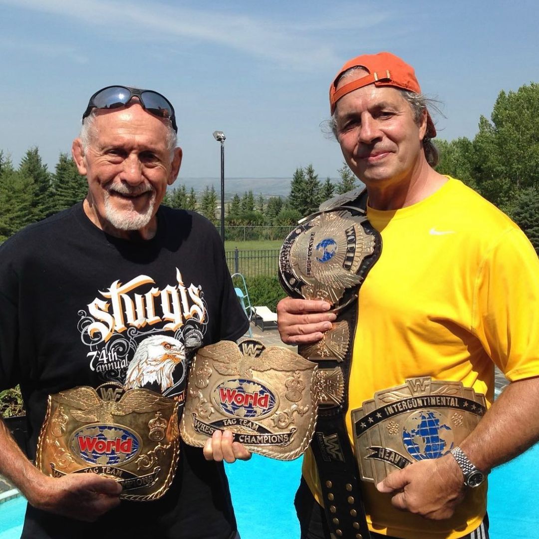 Reggie Parks with Bret Hart holding the WWF Championship Winged Eagle Intercontinental Championship Tag Team Championship Title Belts